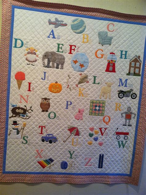 A Quilted Wall Hanging With Alphabets And Animals On Its Sides