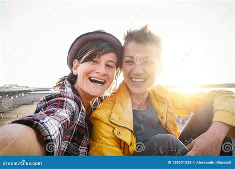 Happy Gay Couple Taking Selfie On The Beach At Sunset Young Lesbians