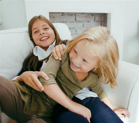 Two Cute Sisters At Home Playing Little Smiling Girl In House Interior
