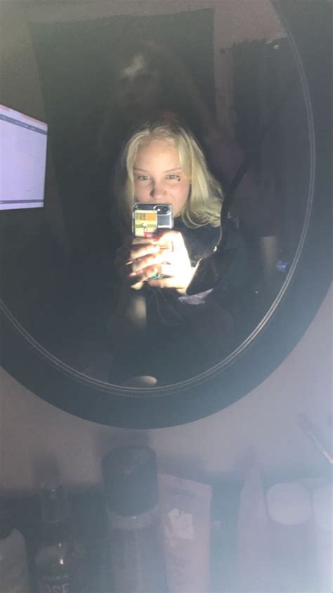 A Woman Taking A Selfie In Front Of A Mirror