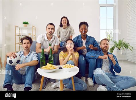 Group Of Happy Diverse Friends Watching Football On Tv While Sitting On