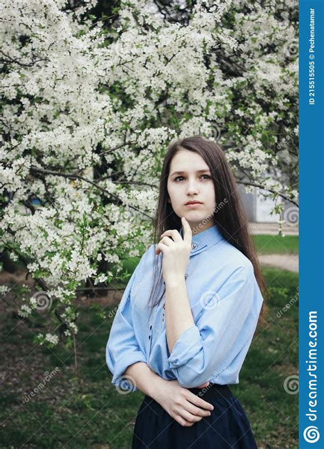 A Pretty Brown Haired Girl Poses Near A Flowering Tree White Flowers On A Tree Garden Cherry