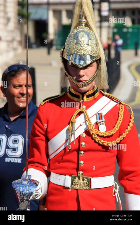 A Royal Horse Guard In Red Uniform And Bronze And Gold Colored Helmet