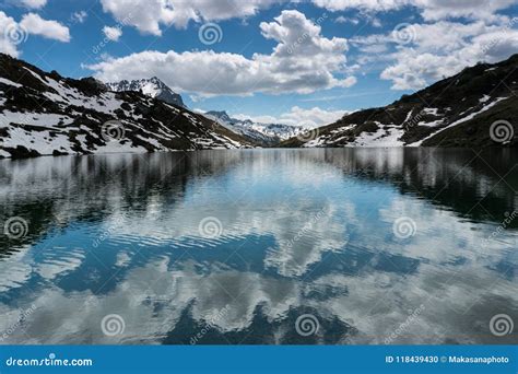 Gorgeous Mountain Lake In The Alps With Reflections And Snow Remnants