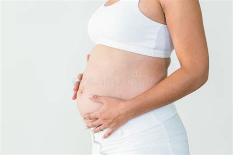Gravid Kvinna Som Rymmer Ett Exponeringsglas Av Vatten Arkivfoto Bild
