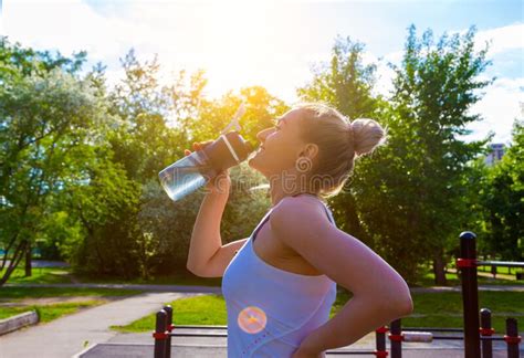 Young Sports Woman Drinking Fresh Water From The Bottle In The Sunny