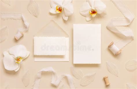 Wedding Cards Near White Orchid Flowers And Silk Ribbons On Light