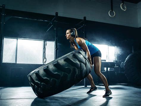 download a woman is lifting a tire in a gym