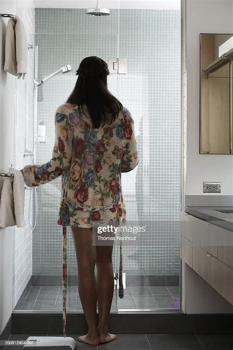 Young Woman Opening Glass Door Into Shower Stall Rear View Photo
