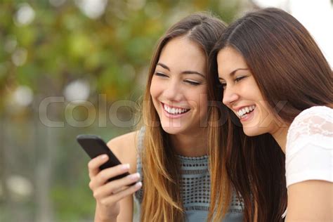 Two Happy Women Friends Sharing A Smart Phone Stock Image Colourbox