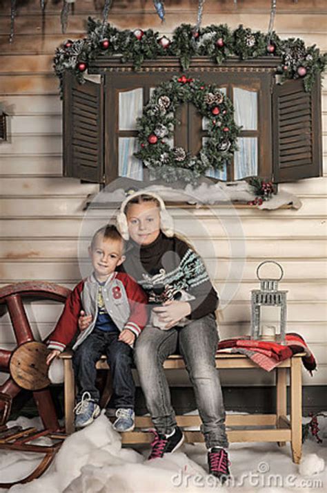 Broer En Zuster Op Een Bank Voor Het Huis In De Winter