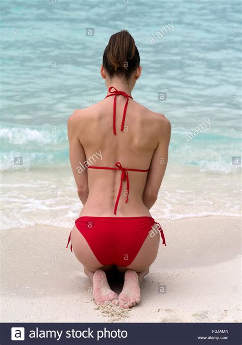 Rear View Of A Woman Kneeling With Bare Back Wearing Bikini On A Stock