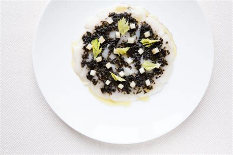 A White Plate Topped With Black And White Food On Top Of A Tablecloth