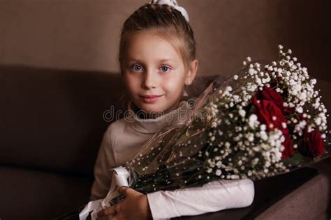 Portrait Of Cute Little Girl Holding Red Rose In Her Hands T To Her