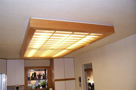 If you are spending the money to update the ceiling light panels, you should invest in fluorescent light covers that actually change the light. Wooden Fluorescent Light Fixture | Wood ceiling lights