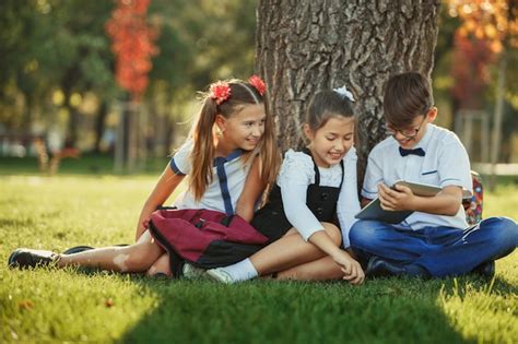 Tres Amigos Adolescentes Escolares Sonrientes Sentados En El Parque En