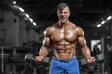 Muscular Man Working Out In Gym Doing Exercises With Dumbbells Strong Male Naked Torso Abs Foto