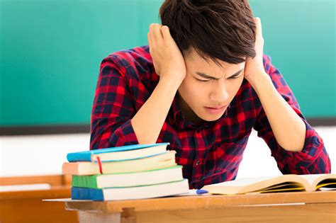 Stressed Student Studying For Exam In Classroom Stock Photo Download