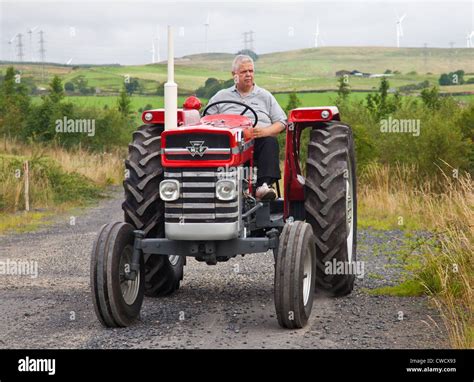 Enthusiast Driving A Red Vintage Massey Ferguson 165 Tractor During An