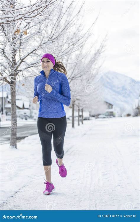Woman Jogging Outdoors During Winter Weather And Snow Stock Image