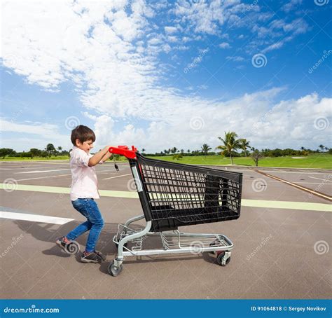 Kid Boy Pushing Empty Shopping Cart At Parking Lot Stock Photo Image