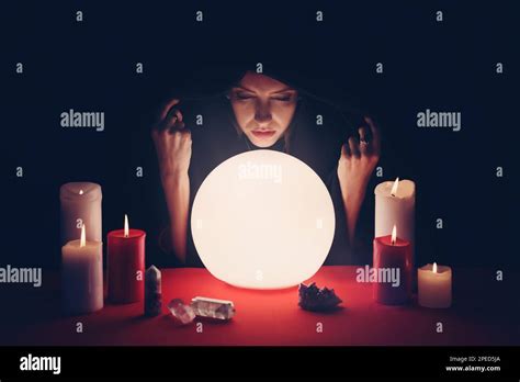 Soothsayer using glowing crystal ball to predict future at table in