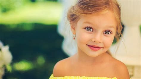 Gadis Kecil Yang Lucu Mengenakan Gaun Kuning Berdiri Di Blur Latar