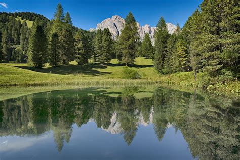 Lake In The Forest With The Mountains In Background Dolomites Stock
