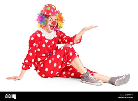 A Clown With Smiling Joyful Expression Sitting Down And Gesturing