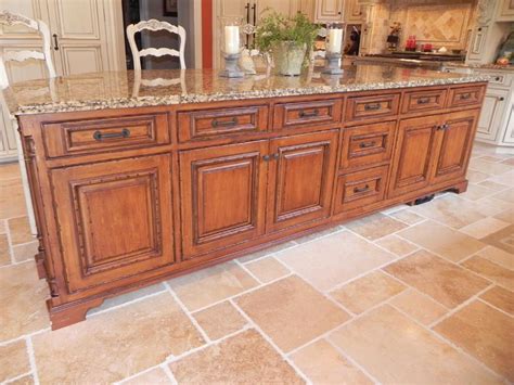 The ornate cabinet hardware and elegant chandeliers further the regal feel of the space. Tuscan Inspired Kitchen - Cabinets by Graber