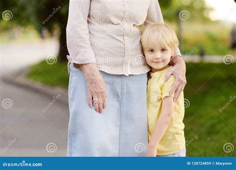 Красивая бабушка и ее маленький внук идя совместно в парк Стоковое Изображение изображение