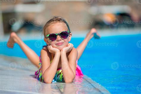 Little Happy Girl In Outdoor Swimming Pool Enjoy Her Vacation 18048131