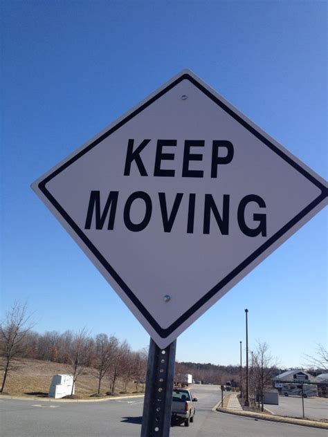 A White And Black Sign That Says Keep Moving