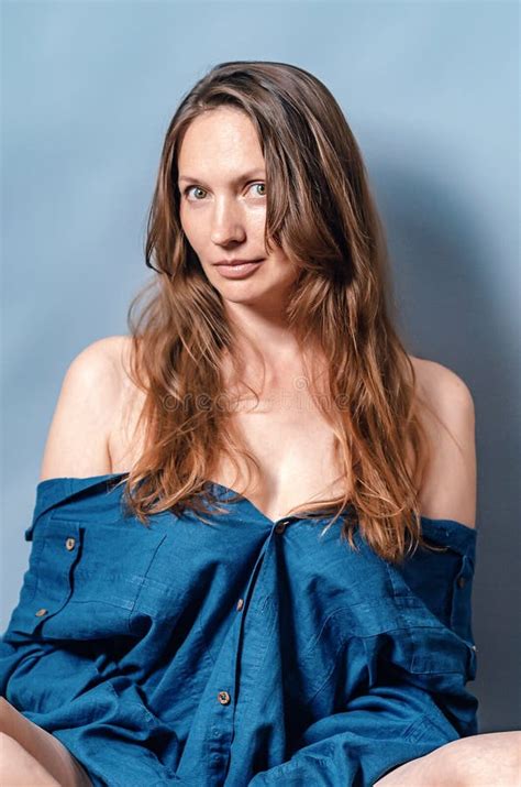 Retrato De Una Mujer Con El Pelo Largo Y Los Hombros Desnudos Camisa Azul Sentada En Un Fondo