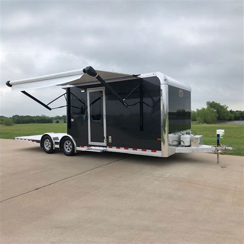 An Enclosed Trailer Is Parked In A Parking Lot With The Door Open To