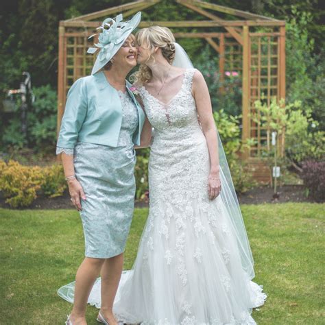 The Mother Of The Bride Poses With The Bride In The Beautiful Gardens
