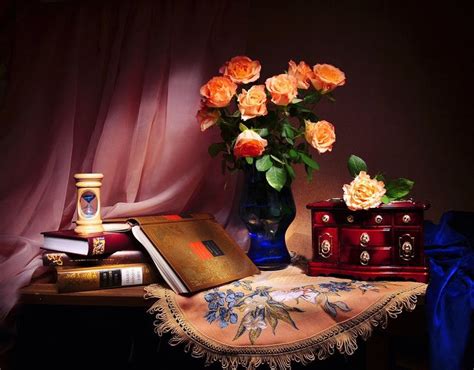 A Table Topped With Books And Flowers Next To A Vase Filled With Orange Colored Roses
