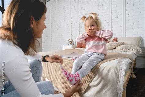 Mom Takes Off Her Little Daughters Socks And Tickles Her Feet A Little