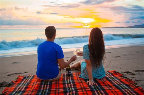 Premium Photo Couple Having A Picnic On The Beach Drinking Wine