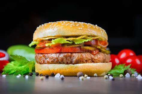 Delicious Juicy Burger With Fresh Tomatoes Peppers And Herbs Stock