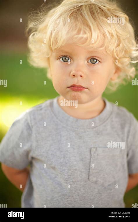 Close Up Portrait Of Innocent Blonde Toddler Boy With Curly Hair In