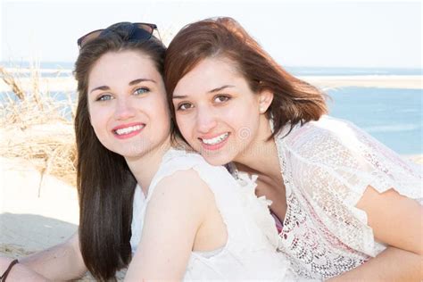 position lesbienne de couples à la plage dans l amour regardant dans la caméra photo stock