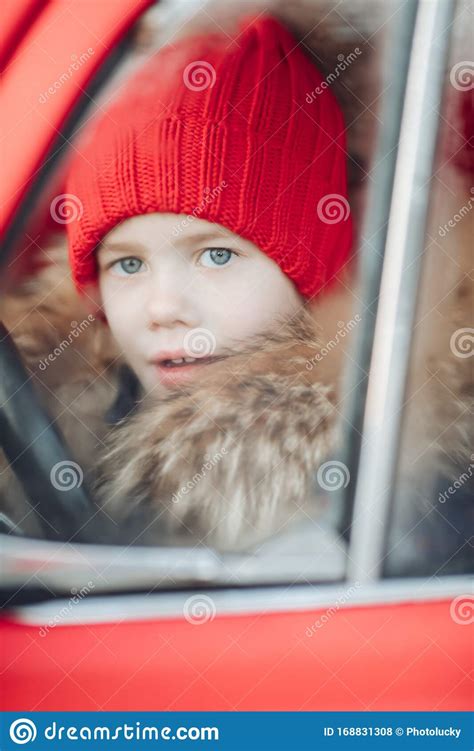 Smiling Cute Winter Boy In Red Hat Sitting In Car Having Fun Stock