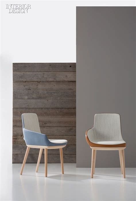 Two Chairs Sitting Next To Each Other In Front Of A Wood Paneled Wall
