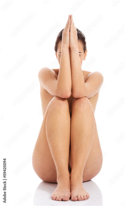 Foto De Beautiful Naked Woman Sitting With Hands And Legs Together Do