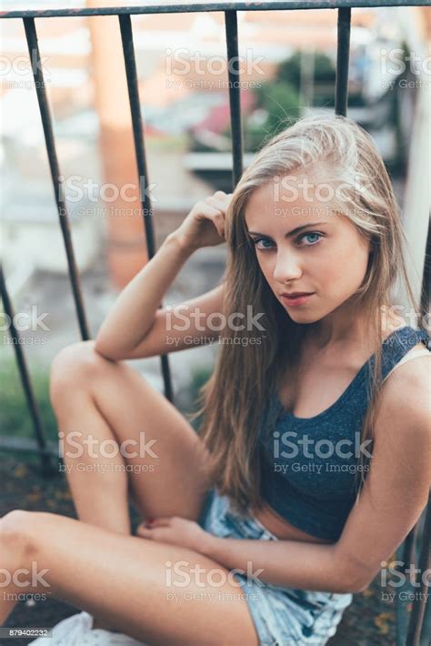 Young Fit Beautiful Blonde Woman Sitting On The Stairs Posing Stock