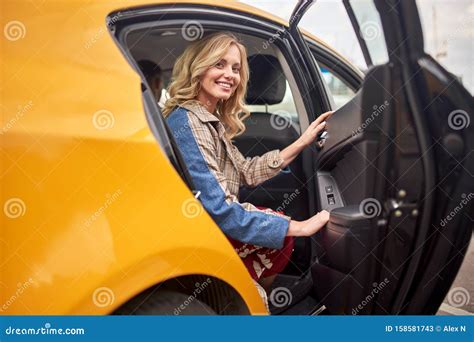 Image Of Happy Blonde Sitting In Back Seat Of Yellow Taxi With Open