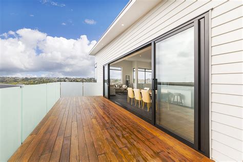 Stained Decking With Black Joinery And White Weatherboard