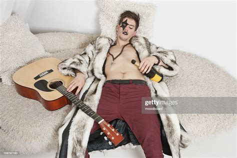 Drunk Young Man With Guitar Sleeping On Sofa Photo Getty Images