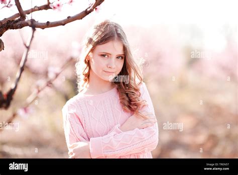 Beautiful Blonde Teenage Girl 14 16 Year Old Posing In Peach Garden Looking At Camera Elegance